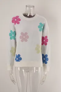 Detailed view of white crewneck sweater with vibrant colorful knitted flower patterns