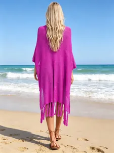 Back view of magenta crochet beach cover-up featuring long tassel hem details