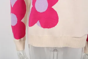 Detail shot of cream knit sweater showing vibrant pink and lavender floral patterns.