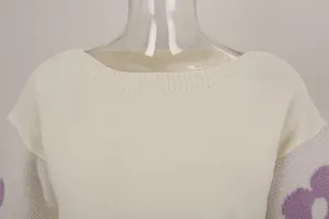 Close-up view of ribbed boat neck and knit texture on cream floral sleeve sweater