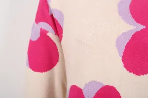 Close-up of knit sweater with vibrant pink and purple floral pattern detail