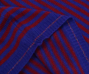 Macro-detail van paars en rood gestreepte gebreide stof met subtiele glitterdraad weave