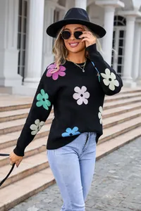Detail of black knit sweater with colorful flower patterns and comfortable round neck
