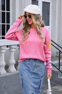 Western style pink oversized knit sweater with floral sleeve details and boat neck.