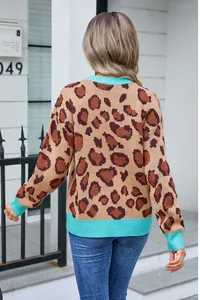 Detailed back view of a leopard print knit sweater with turquoise ribbed cuffs and hem.