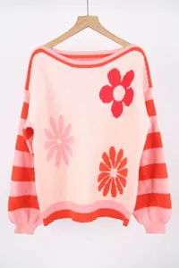 Detailed shot of pink and red knit sweater featuring floral patterns and striped sleeves