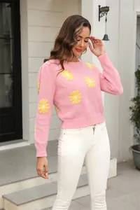 Modern pink knitted sweater featuring vibrant yellow daisy patterns and a comfortable crewneck