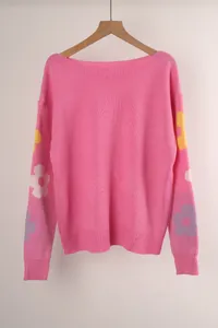 Cozy pink loose-fit knit sweater featuring a boat neck and colorful floral sleeve patterns