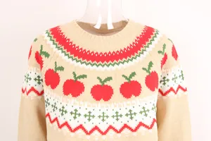 Detalle de suéter de punto navideño con estampados de manzanas rojas y cuello redondo.