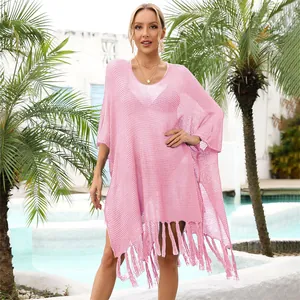 Pink oversized hollow-out beach cover-up with fringe tassels, detail view on blonde model