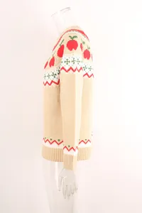 Detalle lateral de un jersey de punto navideño beige con motivos de manzanas y líneas zigzag