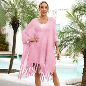 Detailed view of pink knit beach cover-up featuring fringe tassels and hollow-out design.
