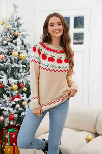 Vista de estilo de vida de un suéter navideño beige con patrones de manzanas rojas y verdes
