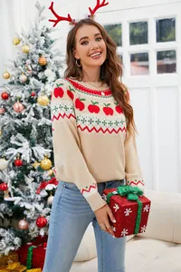 Mujer sonriente con un suéter navideño festivo con patrón de manzanas en un hogar