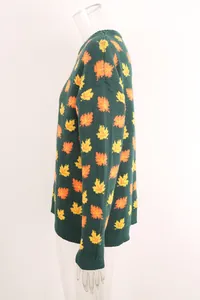 Side view of dark green knit sweater with orange and yellow maple leaf pattern.