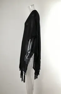 Detail of black crochet knit beach cover-up with stylish tassel hem and hollow-out design
