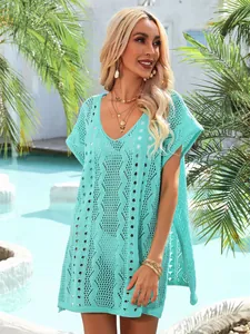 Eleganter türkisfarbener Häkel-Strand-Überwurf, präsentiert von einem Model am Poolrand