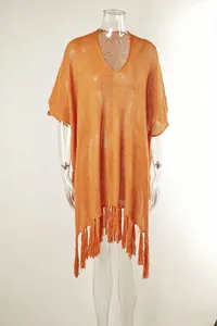 Stylish orange hollow-out knit beach cover-up with boho tassel hem on mannequin