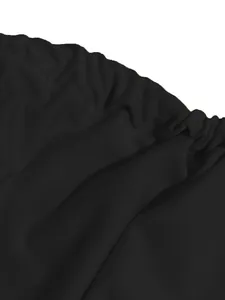 Close-up detail of the black fabric and pleated waist of the sexy two-piece maxi dress.