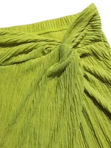 Close-up of lime green crinkled fabric with knot detail on the waist
