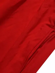 Détail en gros plan montrant la texture du tissu côtelé rouge vif de cet ensemble