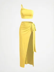 Detail view of a vibrant yellow one-shoulder crop top and high-slit long skirt set.