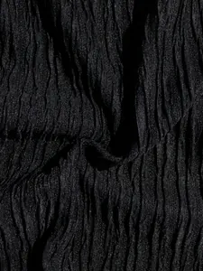 Detailed macro view of black pleated fabric showing fine vertical crinkle texture