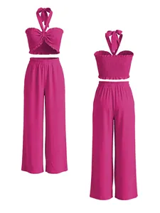Conjunto de dos piezas magenta con top halter fruncido y pantalones de pernera ancha.