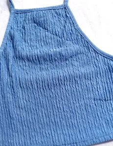 Close-up macro view of the blue crinkled fabric texture on a summer halter top detail.