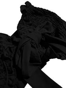 Detalle de top tubo negro fruncido que muestra el lazo y las texturas de volantes