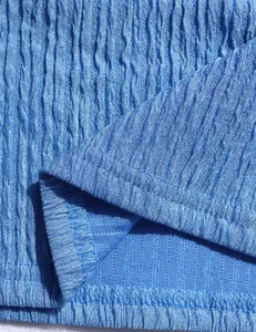 Macro view of blue crinkled fabric texture showing fine stitching details.