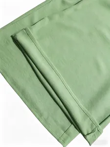 Primer plano de la textura de la tela verde y las costuras del conjunto de pantalón.