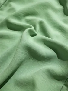 Primer plano de tela texturizada verde claro para conjunto de verano de dos piezas