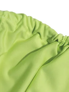 Macro view of neon green fabric detail showing elasticated waistband and fine stitching