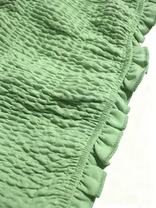 Primer plano del detalle de la tela fruncida verde de un conjunto bandeau