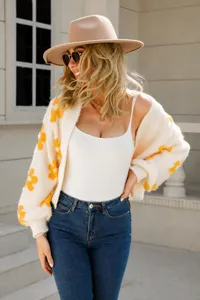 Close-up of a women's beige knit cardigan with vibrant yellow flower patterns