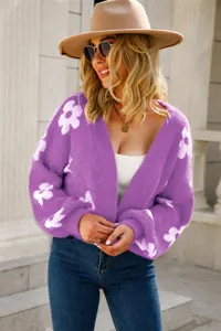 Stylish women's purple fuzzy knit cardigan featuring bold white floral patterns outdoors