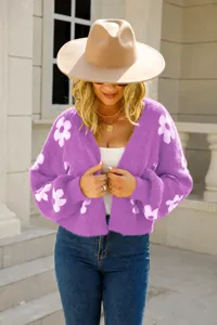 Close-up detail of soft purple knit cardigan featuring vibrant white floral patterns