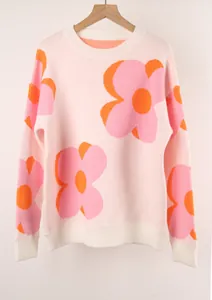 Close-up view of the oversized pink and orange floral pattern on a soft knit sweater.