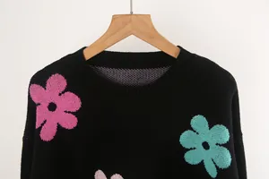 Macro view showing the soft knit texture and colorful flower pattern on the sweater