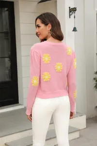 Back view of a pink knit sweater featuring yellow daisy flower patterns