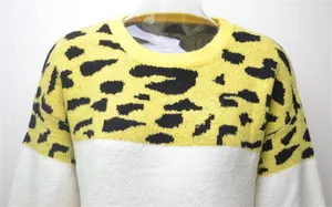 Detail view of yellow leopard print and white color-block pullover knit sweater
