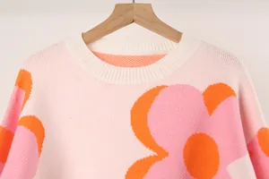 Close-up of a women's crew neck knit sweater with a large pink floral print pattern