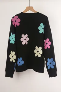 Black round neck knitted sweater with vibrant colorful flower patterns on hanger