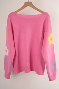 Loose pink knit sweater featuring flower embroidered sleeves and a boat neckline