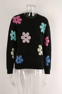 Detailed front view of a black crewneck knit sweater featuring multi-colored flower patterns.