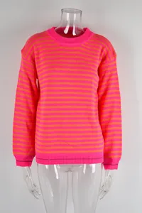 Levendige roze en oranje gestreepte gebreide trui met lange mouwen op een mannequin.
