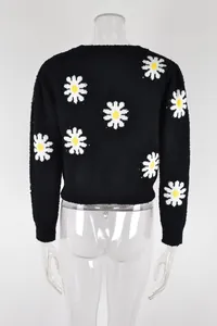 Detailed back view of a black knit sweater with white daisy floral patterns on a mannequin