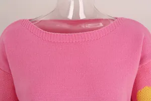 Close-up detail of a pink boat neck knitted sweater with fine ribbed collar texture