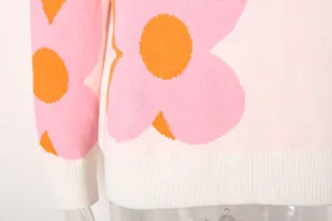 Macro view of knit texture and large pink floral print on white sweater hem